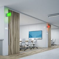 Row of glass-walled meeting spaces with room scheduling occupancy lights illuminated red and green.