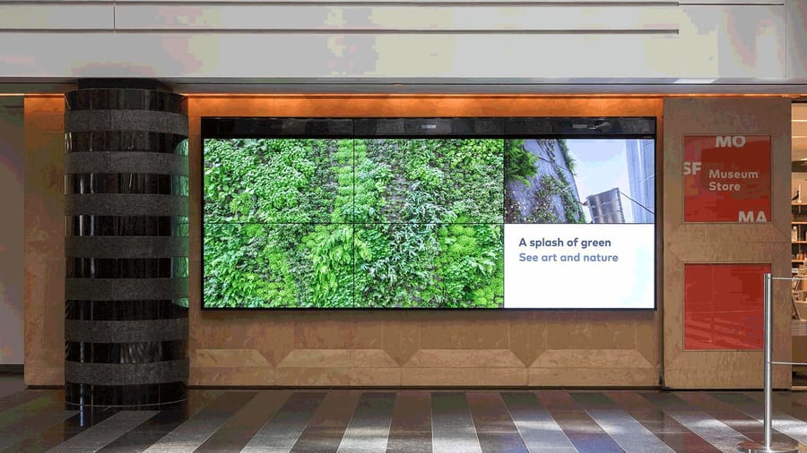 A video wall display in front of a museum store.